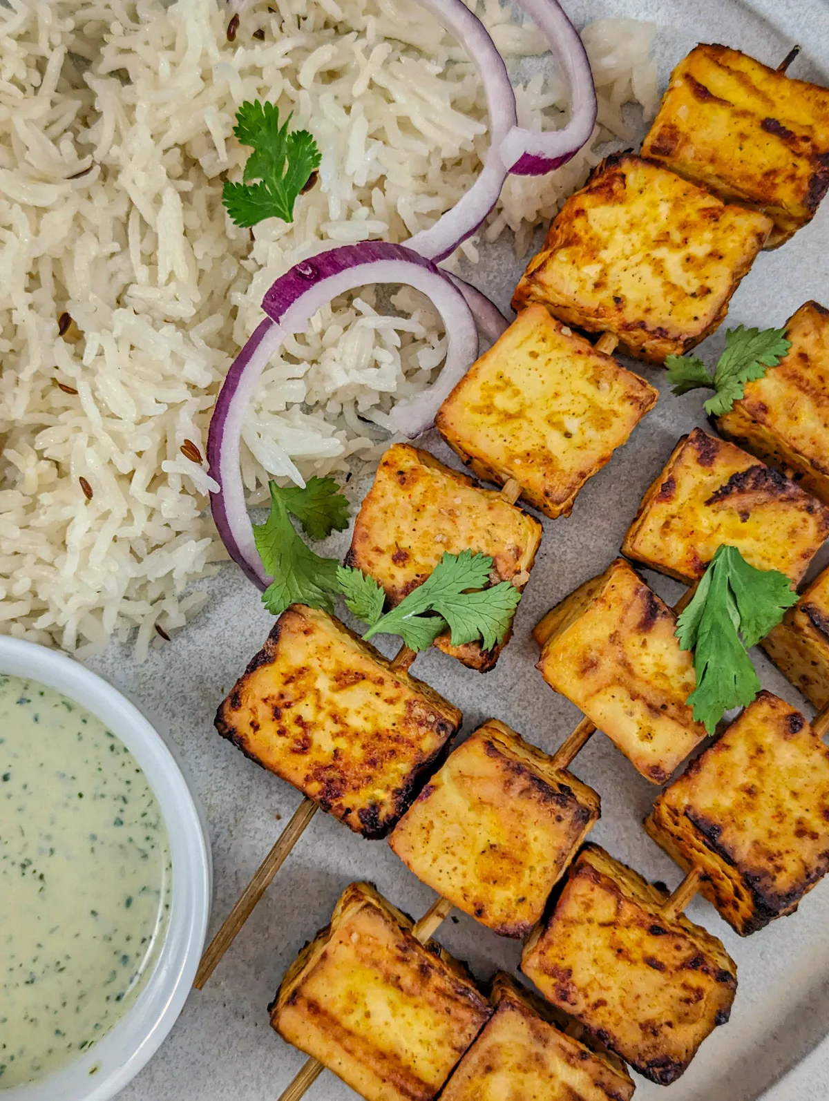 Air fryer paneer on a plate with jeera rice.