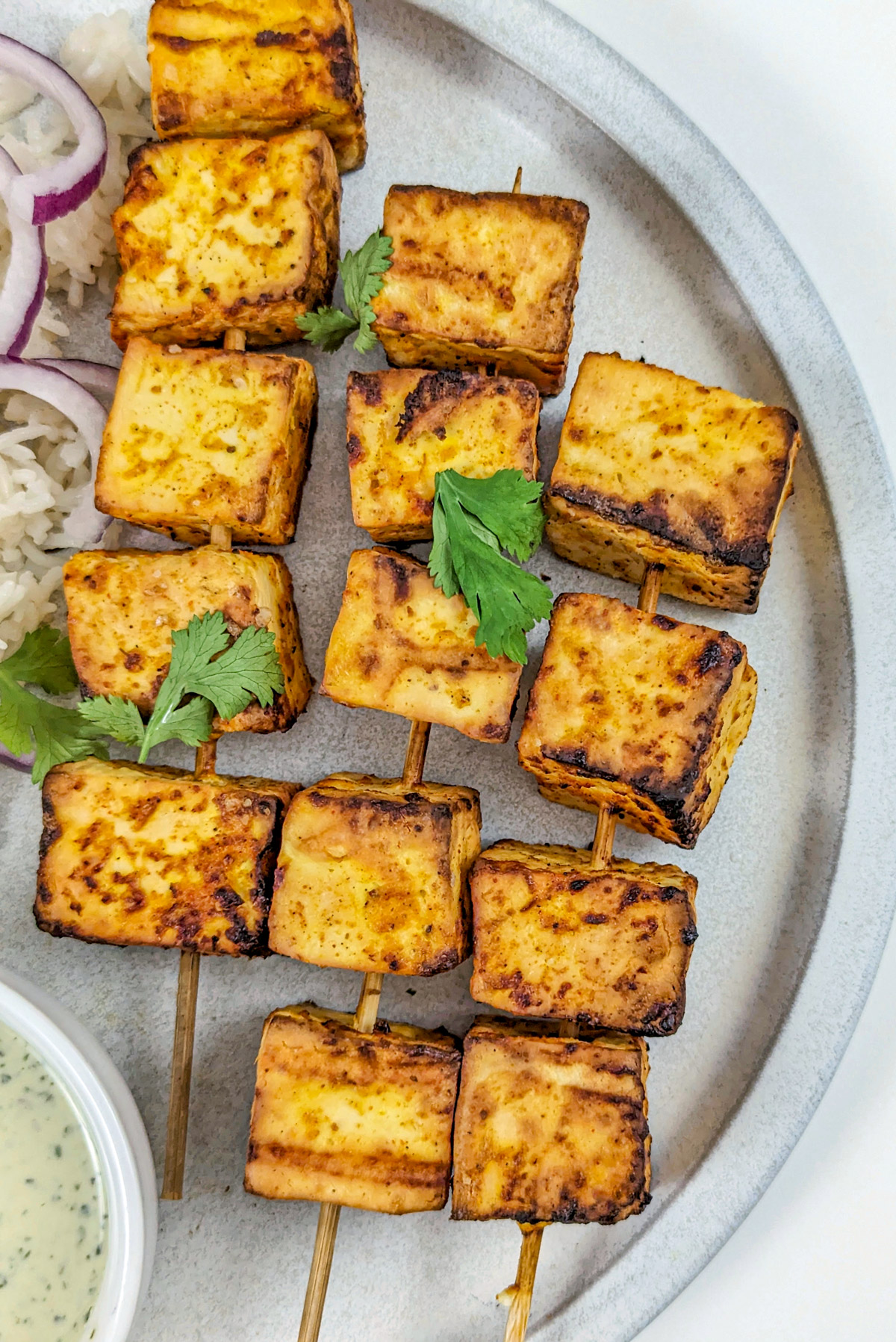 Air fryer paneer on a plate with jeera rice. 