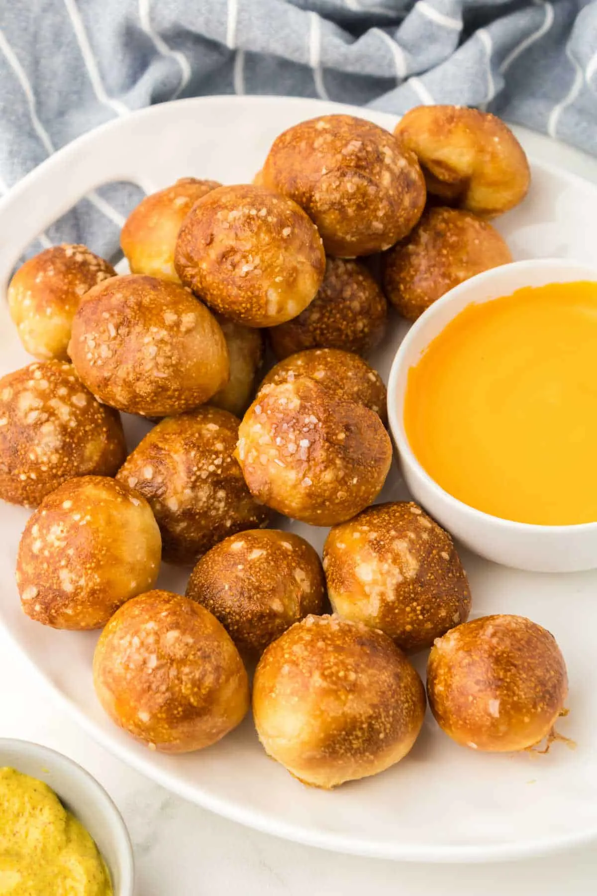 A plate of pretzel bites with cheese sauce.