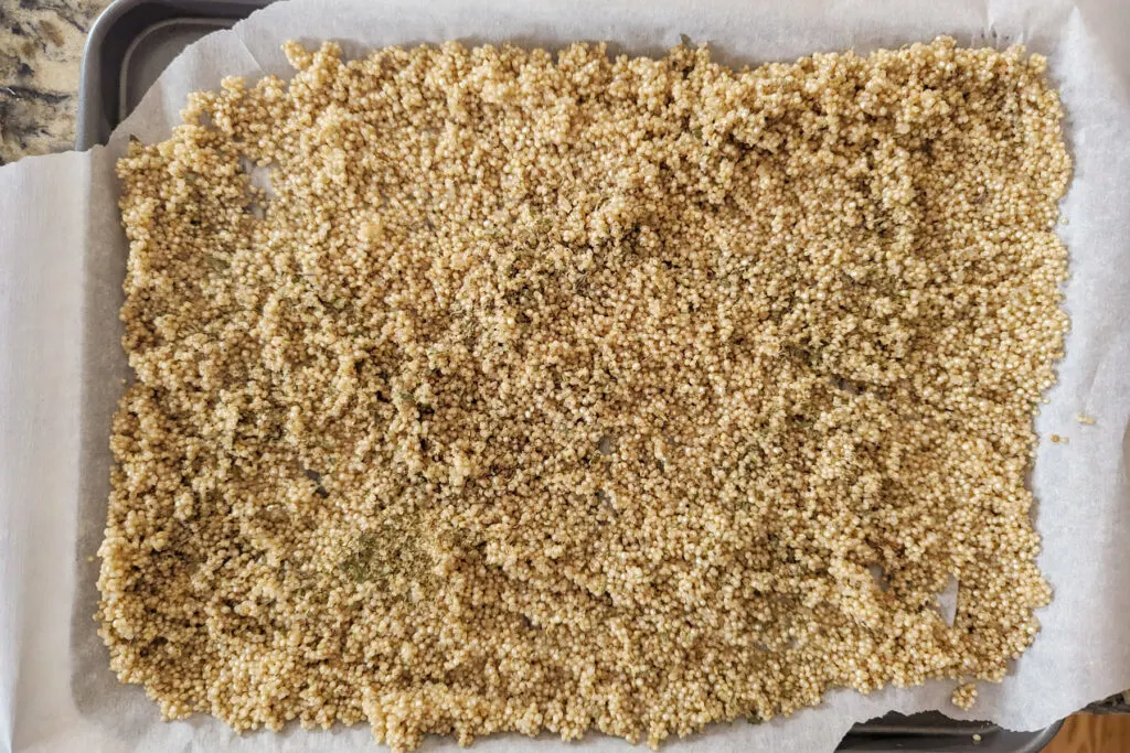 Quinoa spread onto a baking sheet.