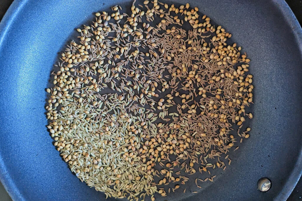 Whole spices toasting in the pan.