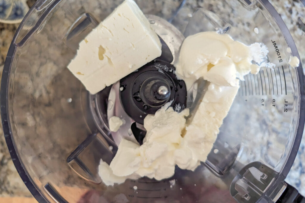 Feta cheese and sour cream in a food processor.