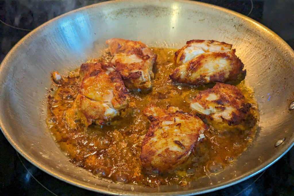 Chicken cooking in a saute pan.