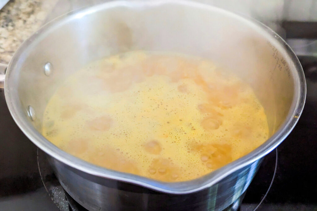 Yellow rice boiling in a saucepan.