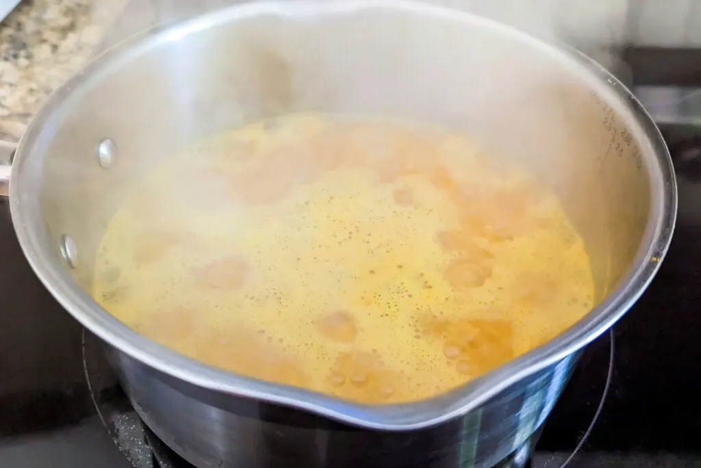 Yellow rice boiling in a saucepan.
