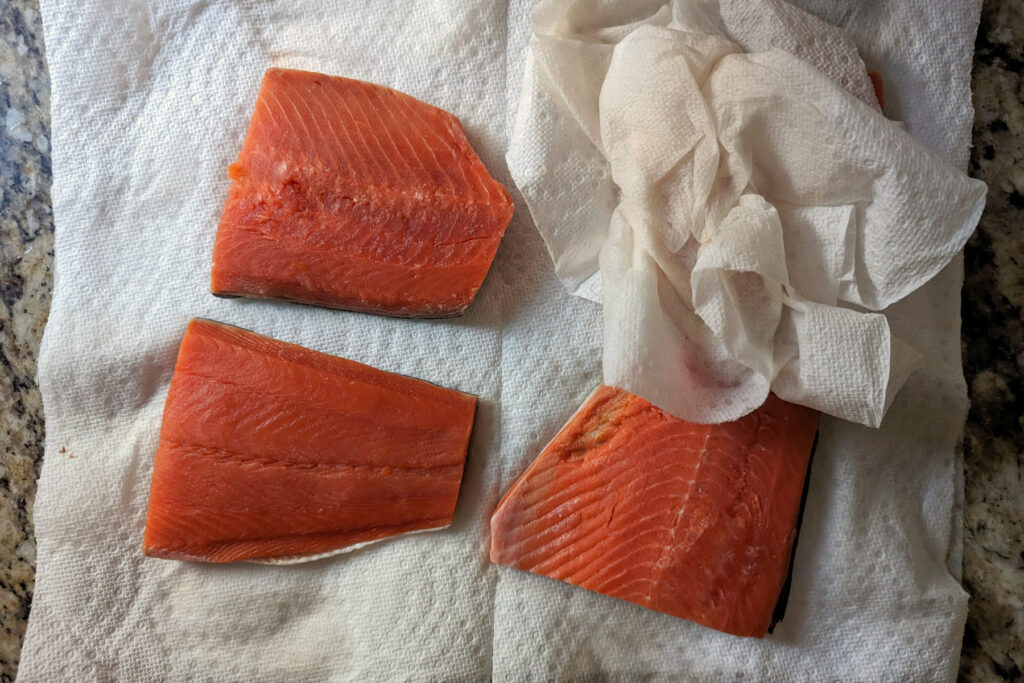 Drying the salmon fillets.