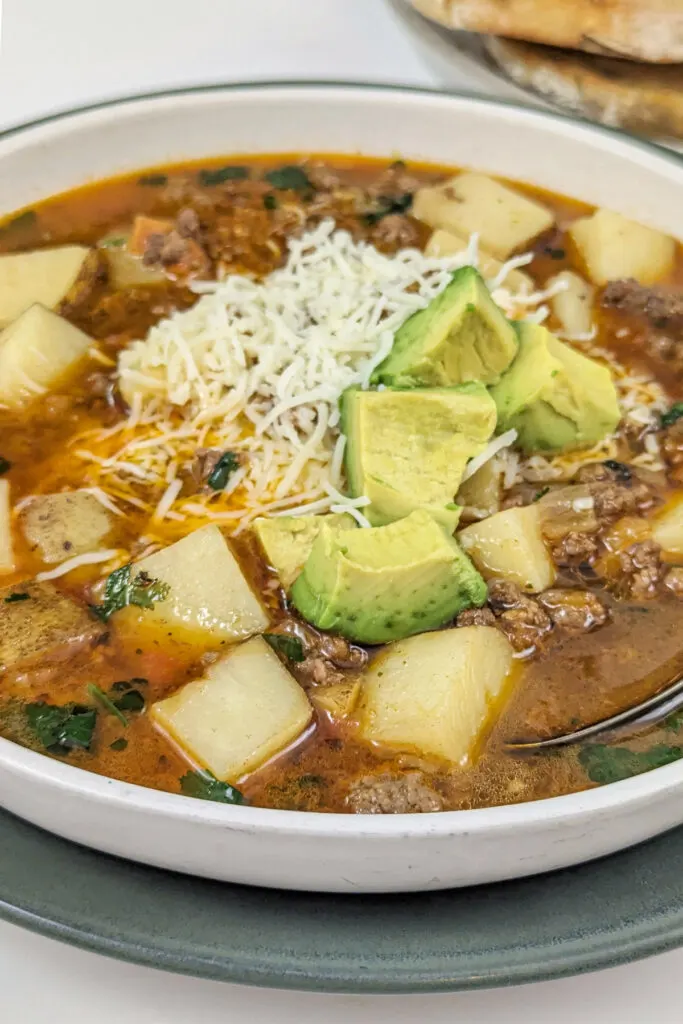 Picadillo Soup in a bowl with toppings.
