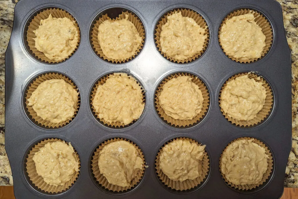 Batter divided into a muffin tin.