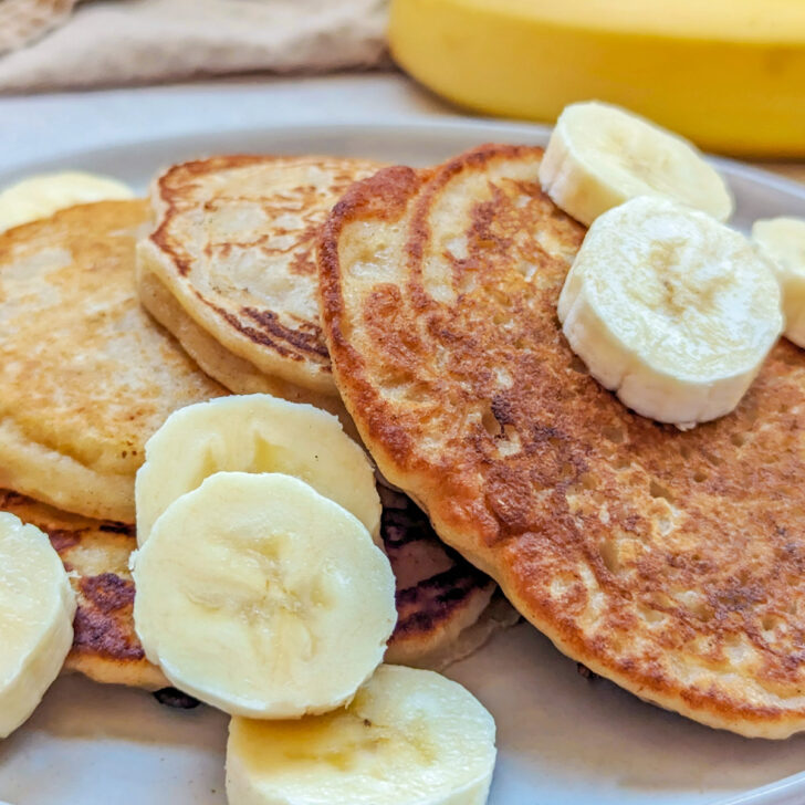 Sourdough banana pancakes with syrup and banana slices.