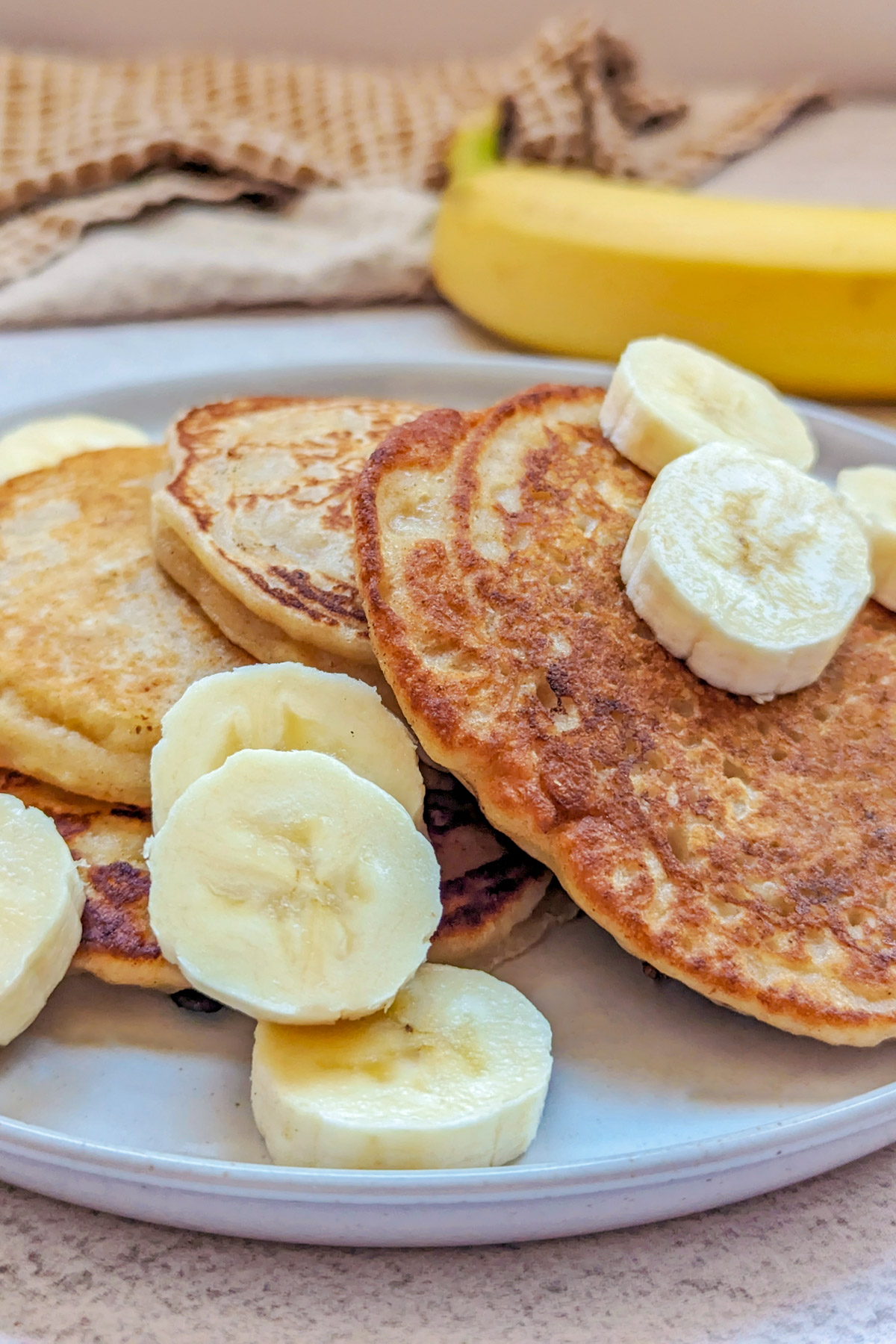 Sourdough banana pancakes with syrup and banana slices. 