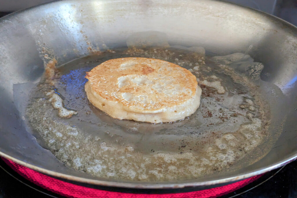 A flipped pancake in a skillet.
