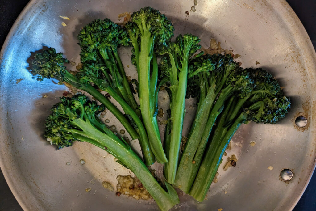 Broccoletti searing in a pan.