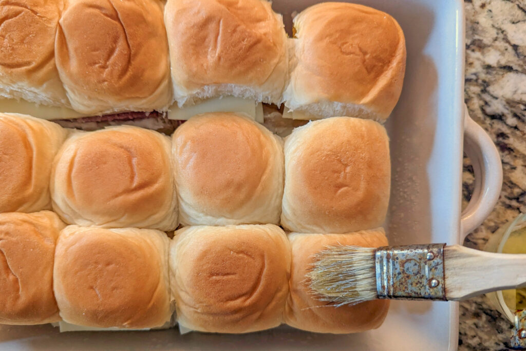 Butter spread onto the tops of the sliders.