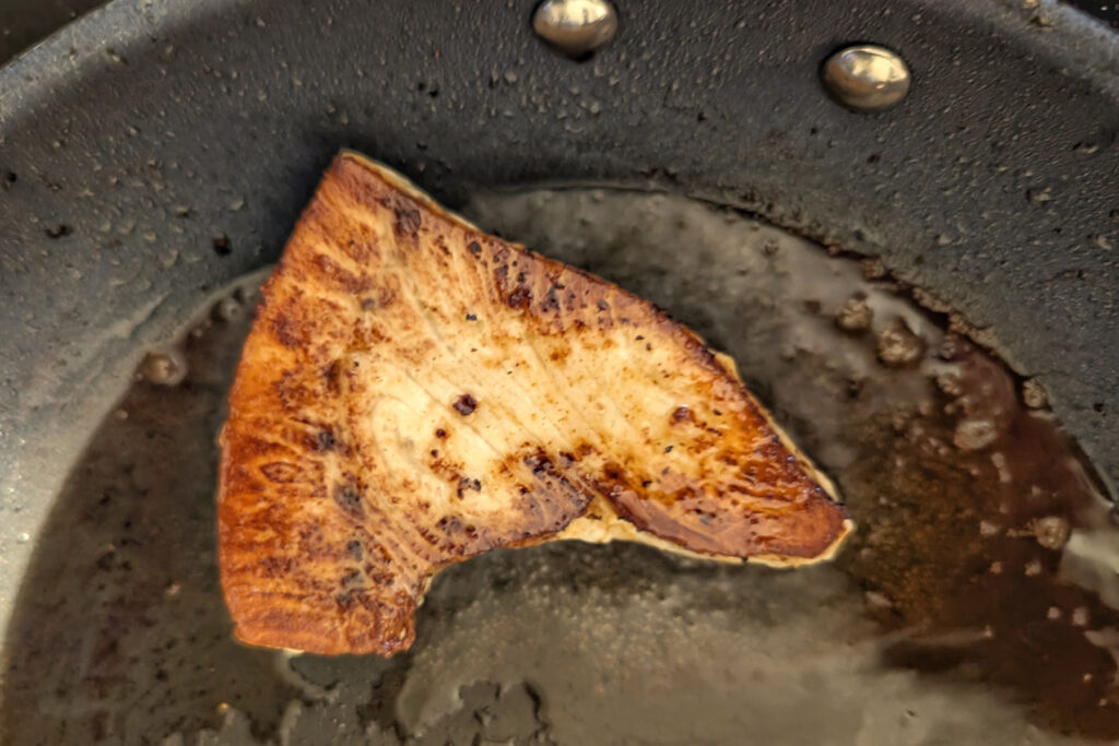 Swordfish searing in a pan.