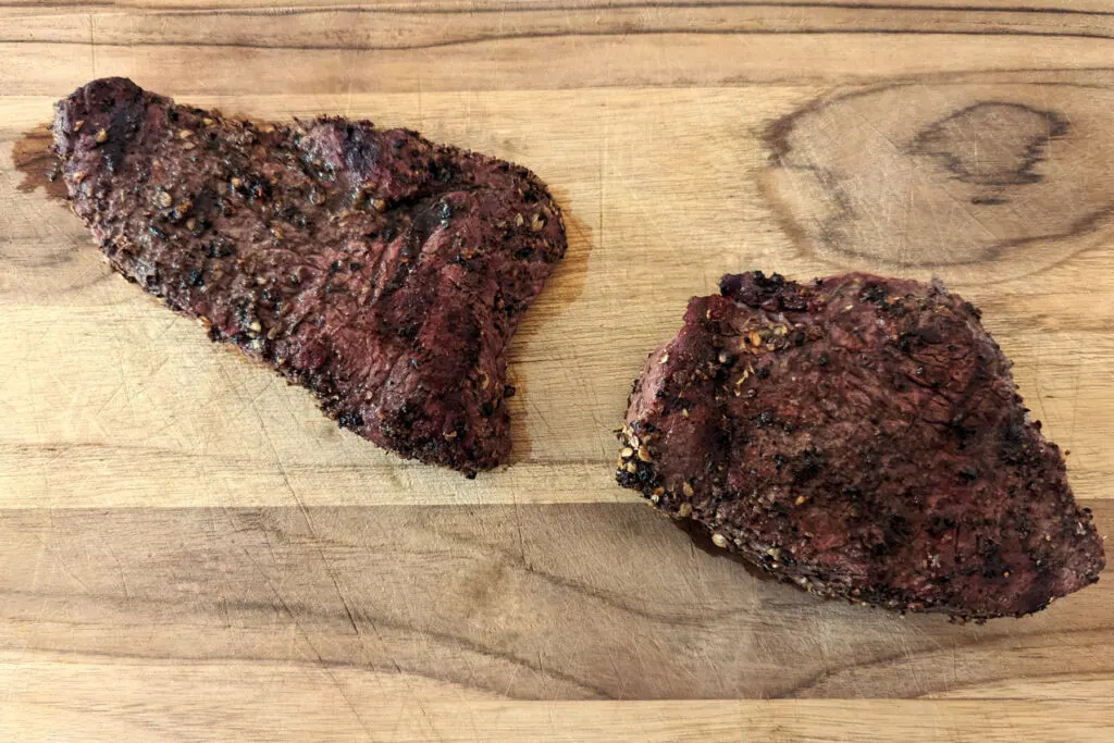 Grilled bison steak resting on the cutting board.
