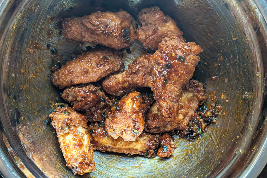 Tossing the wings with soy garlic sauce.