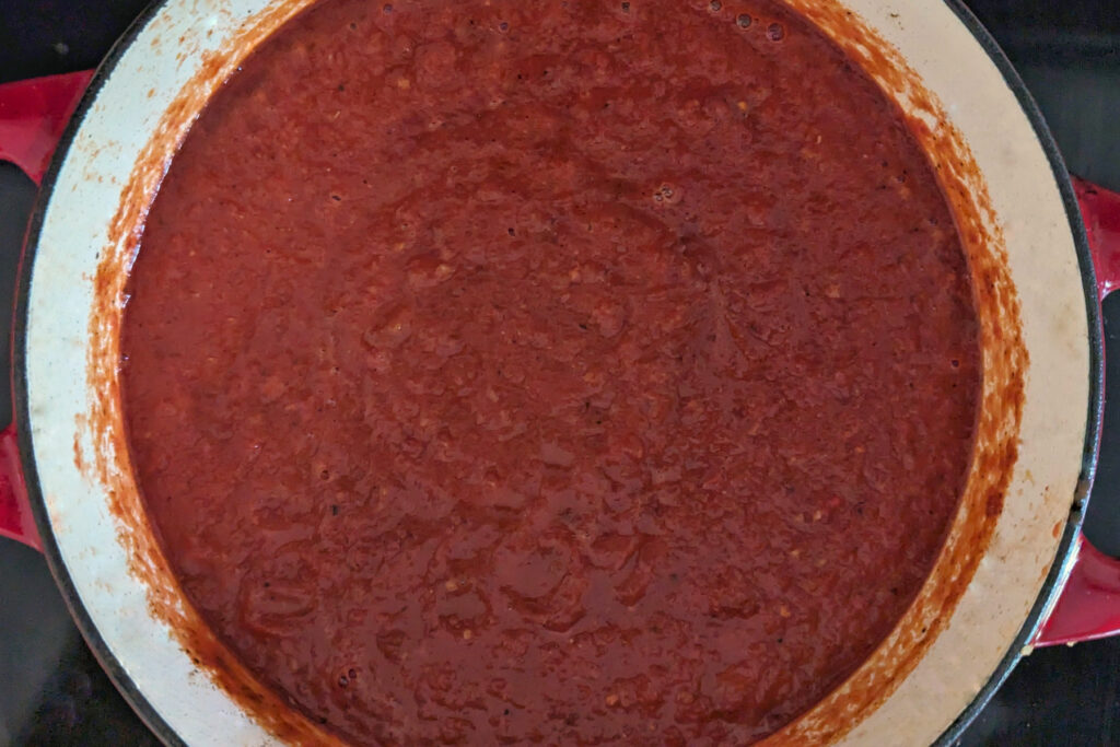 Sauce cooking in a Dutch oven.