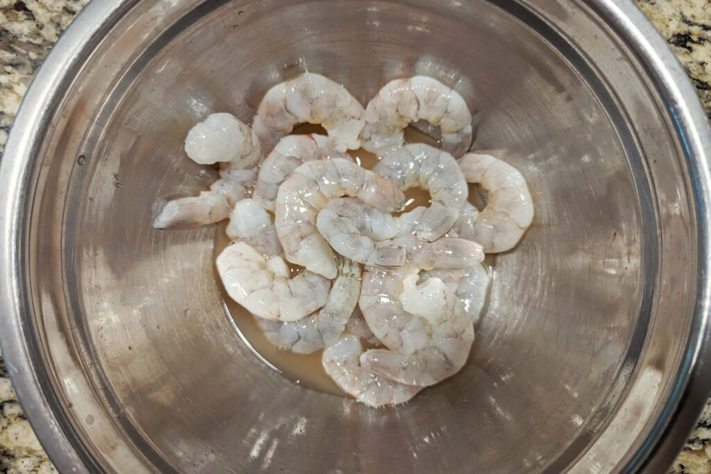Shrimp marinating in a bowl.