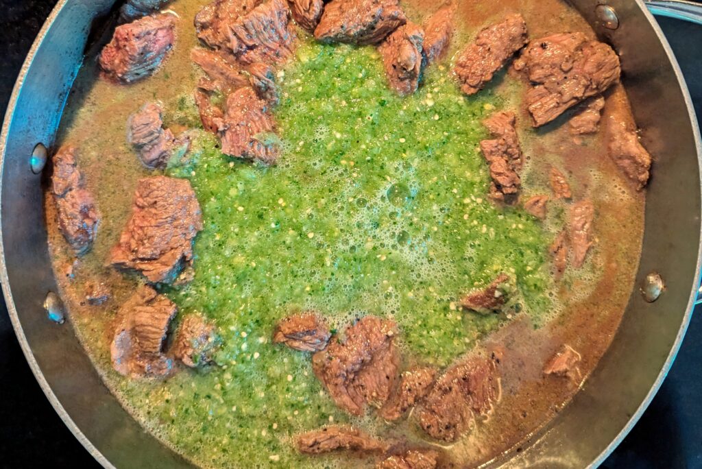 Beef cooking with salsa in a pan. 