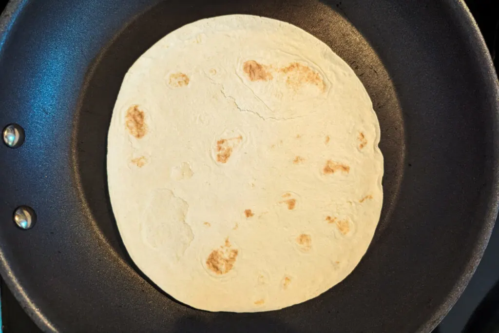 Flour tortilla warming in a pan.