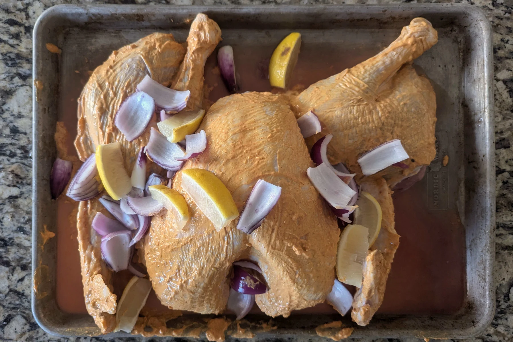 A marinated turkey on a baking sheet.
