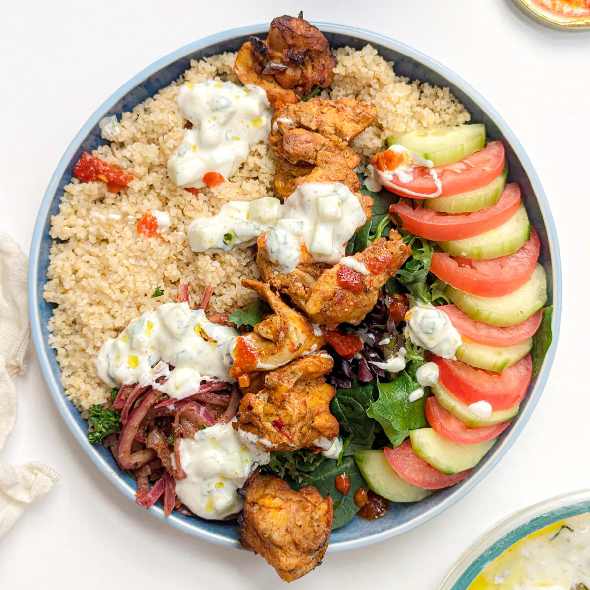 Harissa chicken bowls in serving dishes.